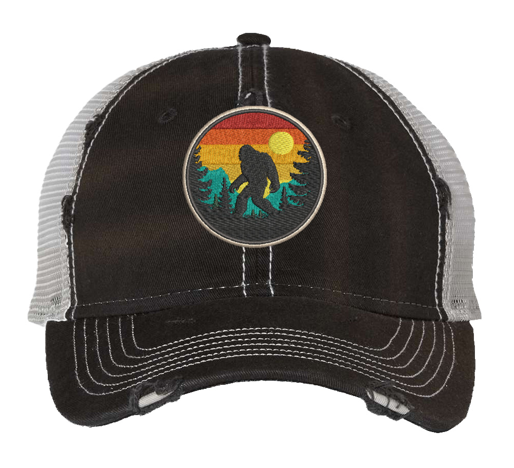Distressed Bigfoot trucker hat with embroidered Sasquatch patch and mesh back panel for outdoor adventures